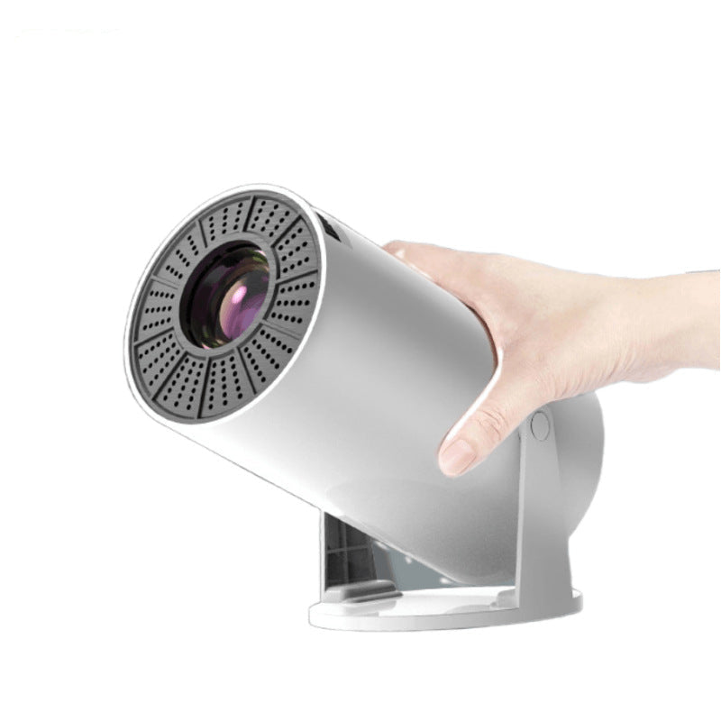 Hand holding a gray high- definition projector on a white background