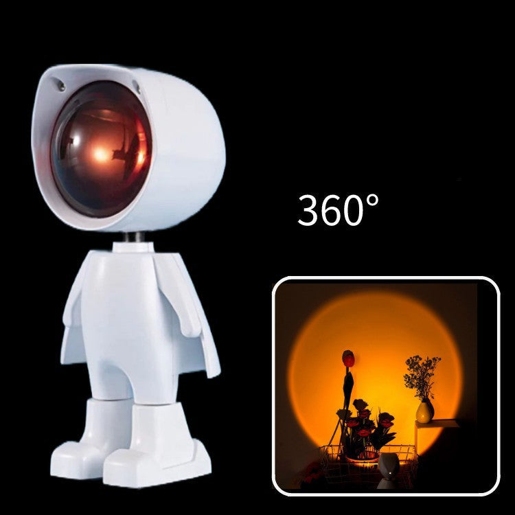 A white robot-like lamp with a red light on a black background.