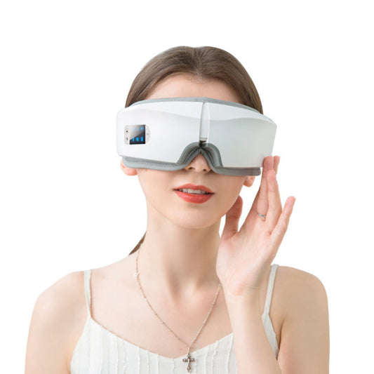 Woman wearing a white bluetooth eye massager with a digital display on a white background